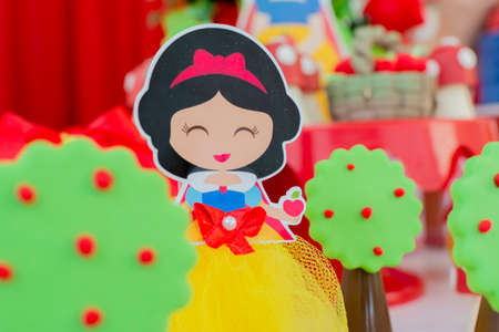 Florianopolis - Brazil. March 27, 2020: Colorful Birthday party decoration, theme of snow white and the seven dwarfs. Children's fairy tales. Decoration with sweets, cake, ornaments.のeditorial素材