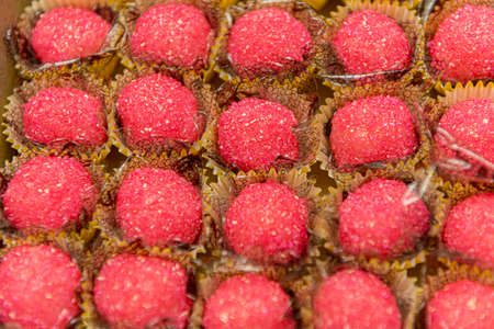 Close up of tasty granulated coconut candies with pink crystal sugar. Typical Brazilian children's...