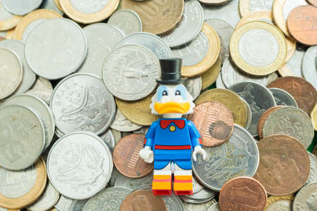 FlorianÃ³polis - Brazil, July 9, 2019: Minifigure of Scrooge McDuck lying.on a lot of coins. Lego minifigures are manufactured by The Lego Group.のeditorial素材