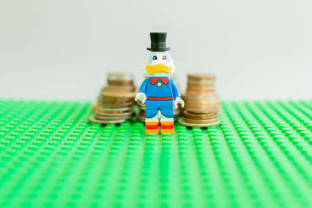 FlorianÃ³polis - Brazil, July 9, 2019: Minifigure of Scrooge McDuck in front of the stack of golden coin like income graph. Lego minifigures are manufactured by The Lego Group.のeditorial素材