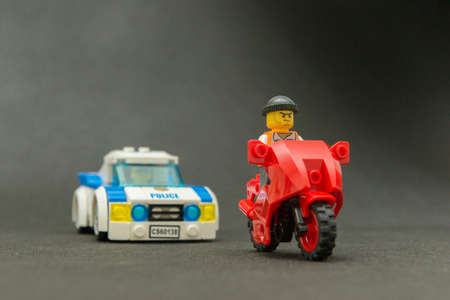Bauru, Brazil. September 15, 2019. Minifigure of a thief riding a motorcycle being chased by a police car. Lego minifigures are manufactured by The Lego Group.のeditorial素材