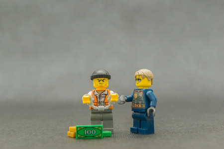 Bauru, Brazil. September 15, 2019: Lego minifigure of thief in handcuffs with police escorting. The...