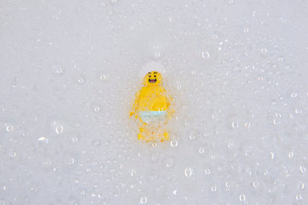 Bauru, Brazil. 7, June, 2022: Lego minifigure of isolated happy man wearing shower cap surrounded by...
