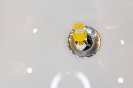 Bauru, Brazil. 7, June, 2022: Top view of Lego minifigure of scared man wearing shower cap and being sucked down the sink drain. Minifigure are made by Lego Groupのeditorial素材
