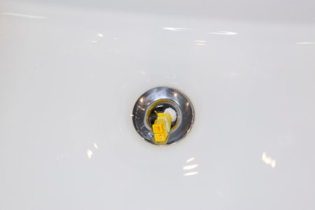 Bauru, Brazil. 7, June, 2022: Top view of Lego minifigure of scared man wearing shower cap and being sucked down the sink drain. Minifigure are made by Lego Groupのeditorial素材