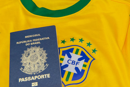 Bauru, Brazil - 11.01.23: Brazilian Football Confederation emblem on football jersey. Soccer players sale and trading concept. Passport and money from fans or players on the Brazilian team t-shirtのeditorial素材