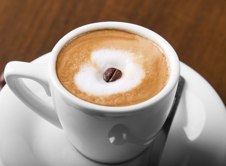 Macchiato coffe with espresso bean in center of steamed milk creamの写真素材
