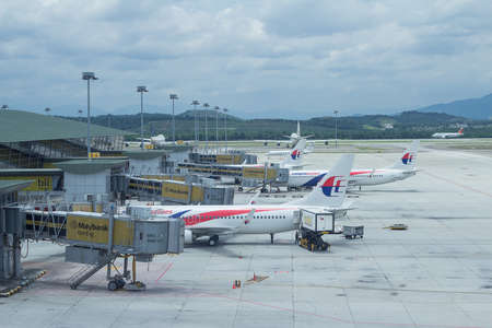 Malaysia Airlines planes prepare for passengers to board, as ground crew prepares the plane for the flight のeditorial素材