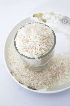 Uncooked rice in a glass on isolated white