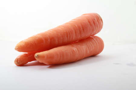 3 pieces of fresh carrot isolated on a white back groundの写真素材