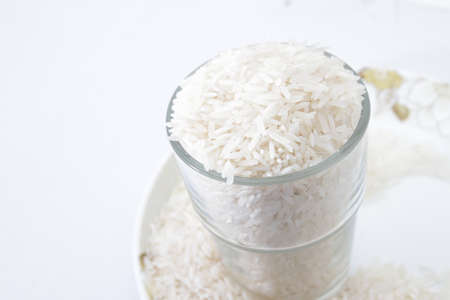 Uncooked rice in a glass on isolated whiteの写真素材