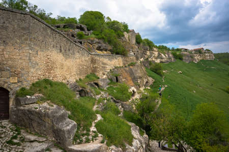 Cave city Tepe-Kerman in the Crimea. The ancient city among the rocks on the background of a mountain rangeの写真素材