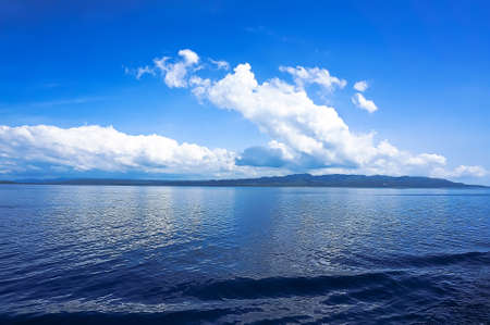 blue sea blue sky horizon with white Cumulus cloudsの写真素材