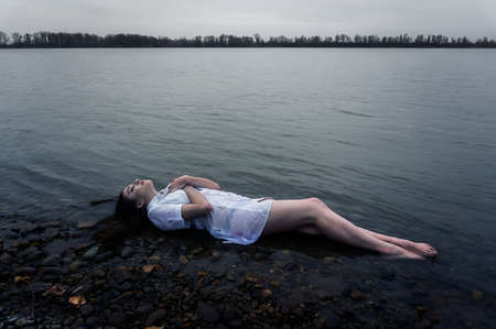 girl lying on the rock of dark river . Ophelia conceptualの写真素材