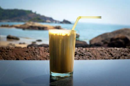 Coffee cocktail in a glass on the table in the background of sea and sky.