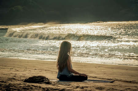 young woman yoga meditation on sunset beach. Gokarna, Indiaの写真素材