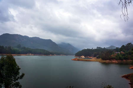 Beautiful landscape with mountain lake amid high mountains with tea plantations and cloud sky. Munnar Kerala India.の写真素材