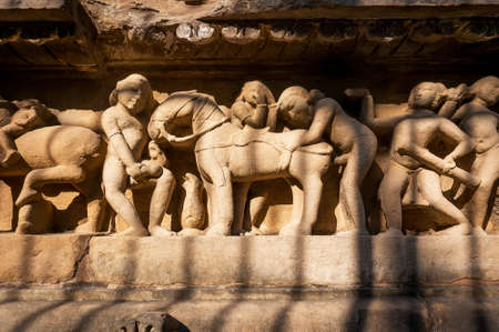 Intimate life of ancient people on stone relief on wall of Khajuraho temple, India. UNESCO Heritage site, built between 950 and 1150 in India, belong to Hinduism and Jainism. Temple of loveの写真素材