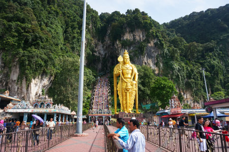 Crowds of tourists flock to A giant gold statue of Lord Muruga stands outside the Batu Caves Photo taken, 2017 in Kuala Lumpur, Malaysiaのeditorial素材