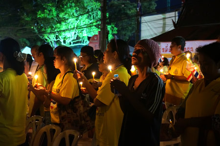 Asians stand with candles. Thais pray for the health of the king. The king's birthday a national holiday in Thailand. December 2, 2015.のeditorial素材