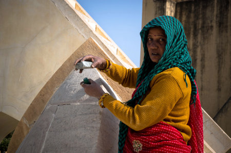 Old Indian woman working on the stone with primitive tools. Knocks a stone on the drill bit. Jaipur, India, 30 January 2017のeditorial素材