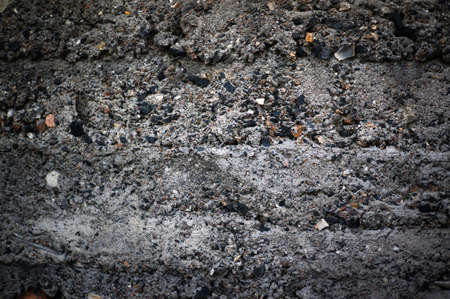 The dark texture of cinder block with coarse rough stones. Exposed aggregate concrete texture...