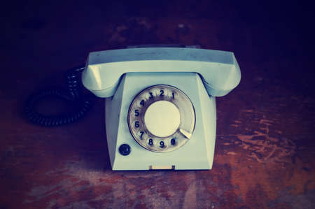 Retro background with rotary telephone on wood tableの写真素材