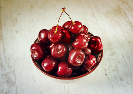 sour cherries dish on white wooden table, directly aboveの写真素材