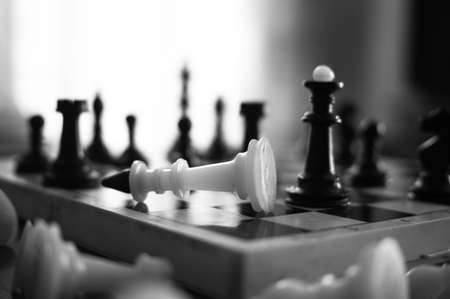 The chess pieces are placed on the chessboard. Defeated white king. The player admitted defeatの写真素材