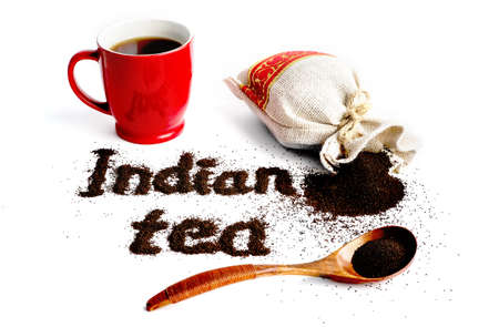 Black leaf tea in a bag isolated on white background. The concept of the traditional Indian tea. Inscription - Indian hour in the form of tea.の写真素材