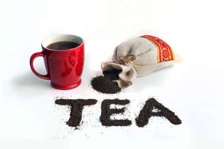 The word tea is laid out small leaf black tea. Red mug of tea a packet and the word tea on an isolated white backgroundの写真素材