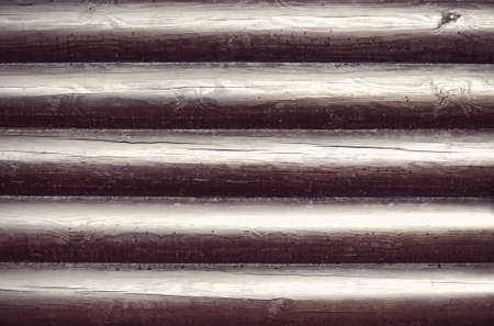 Wooden wall from logs as a background texture. Blackened timber covered with varnishの写真素材