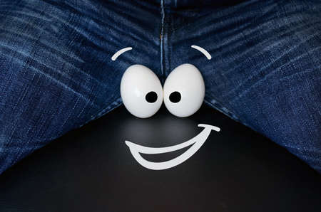 two large chicken eggs as a symbol of male testicle. Cheerful smiley face on the eggs.の写真素材