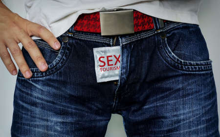 Condom in jeans zipper. Sex tourism - the inscription on the condom. Safety tourism theme.の写真素材