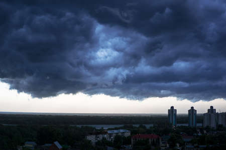 a terrible black cloud is coming to town. dark storm clouds before rainの写真素材