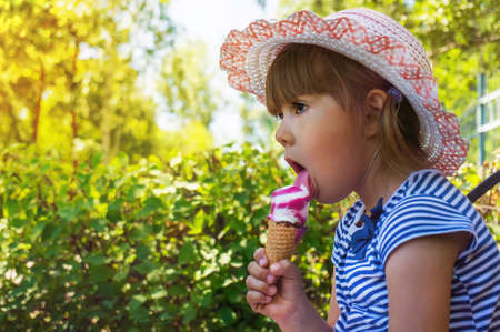 Portrait of a cute girl with ice cream in the park. child outdoors. Flight camping in the Parkの写真素材