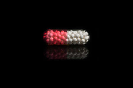 capsule pills isolated on black background. The tablet with the balls insideの写真素材
