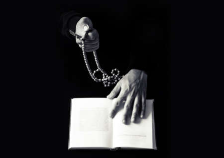 Young praying hands with wooden rosary and Holy Bible. Religion concept black and white photoの写真素材