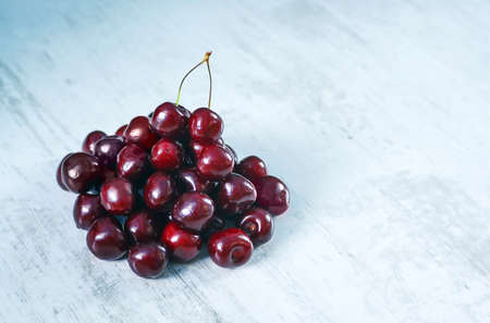 Fresh looking cherries on wooden background with copyspace availableの写真素材