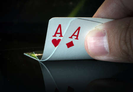 A pair of aces on a black background in hand from puckerman. Winning the game of cards. Playing...