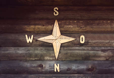 Wooden compass on a wooden wall in a country house. Decorated wall in the form of a compass,...