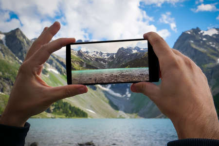 man hand using mobile phone photo. Mountain natureの写真素材