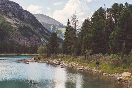 Lake with rocky ridge. Beautiful landscape. The tourist goes over the rocks on the shore of the...