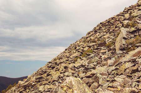 Mountain landscape. Stone deposits on the slopes of a steep mountain. Climbing a steep hillの写真素材