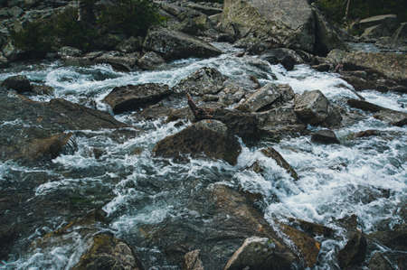 Stone texture of the river. Strong current of a mountain river in the background. Tinted instagram...
