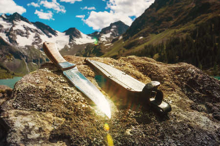 hiking travel knife against a mountain landscape. Flat lay of outdoor travel equipment items for mountain camping trip.の写真素材