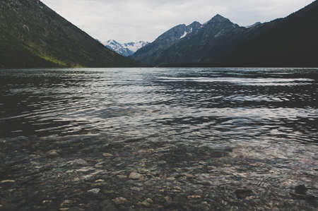 Beautiful mountain lake with turquoise Multinskoe. Clear water in the Altai Republic Siberia Russia. Evening mountain landscape with a lake with transparent water in the foregroundの写真素材