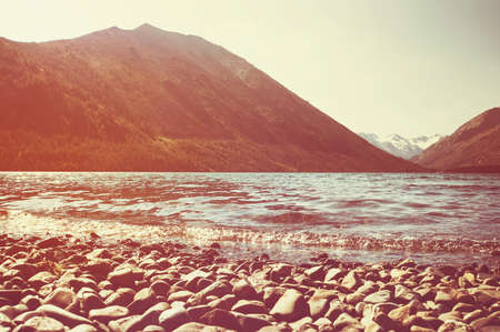 Multinskoe lake with crystal clear fresh water in the Altai mountains. pebble beach at mountain lakeの写真素材