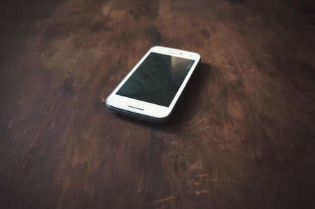 Smartphone on wood background with copy space and text space. old vintage wooden furniture