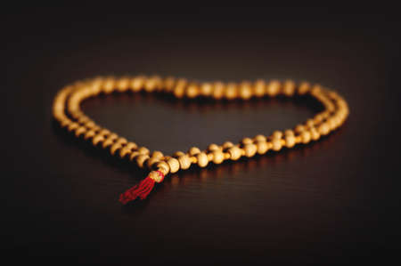 Rosary of sandalwood on a wooden table laid out in the form of a tree. The concept of religion.